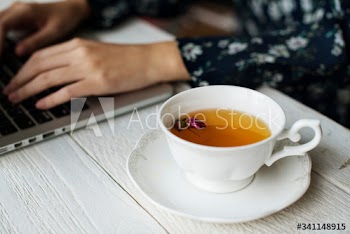 Woman working and a hot cup of floral tea