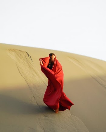 Woman Wrapped in Red Fabric Standing in Desert Sand · Free Stock Photo