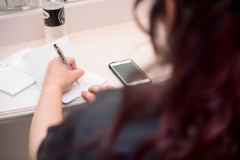 Woman Writing on White Paper
