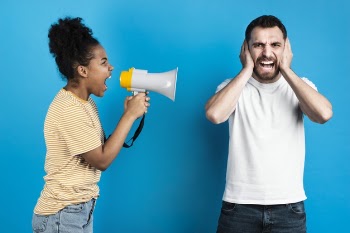 Woman yelling at man through megaphone Free Photo