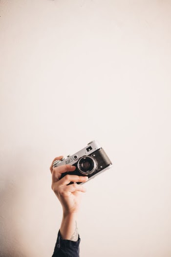 Womans Hand Holding a Camera  · Free Stock Photo