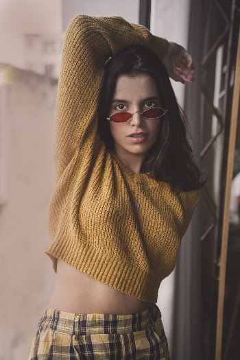 Women's Yellow Knit Sweater Near Brown Metal Wall