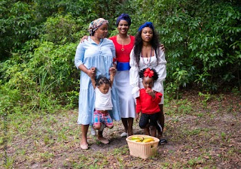 Women and children in park with produce basket