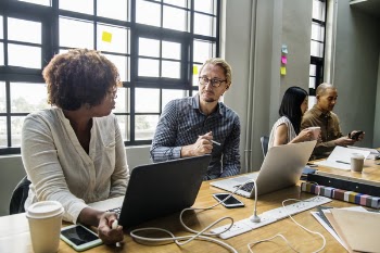 Women and Men Sitting Near Desk