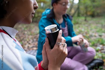 Women drinking from insulated drink containers while camping
