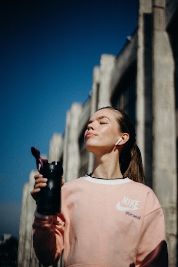 Women Holding a Black Travelling Bottle Close-up Photography
