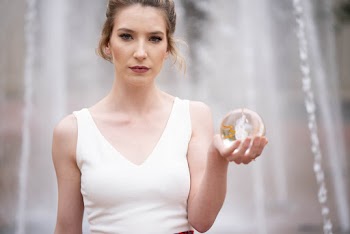Women in White Sleeveless Dress Holding Snow Globe