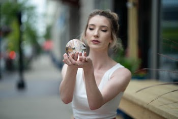 Women in White Top Holding Snow Globe