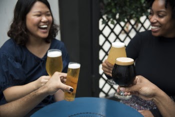 Women Laughing Holding Glass Of Drinks