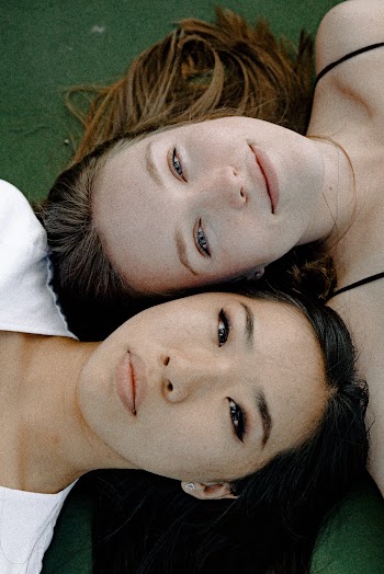 Women Lying on Green Surface