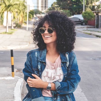women's wearing blue denim jacket standing on the street