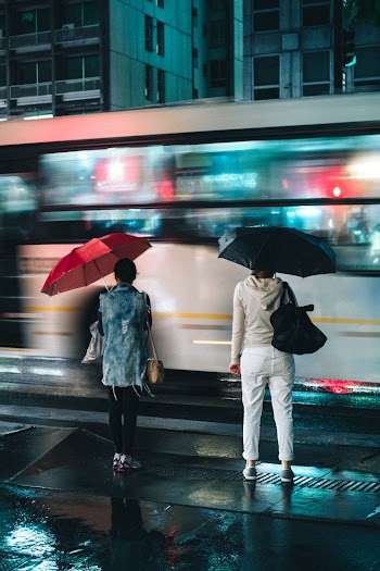 Women Standing Under Open Umbrellas Outdoors during Nighttime