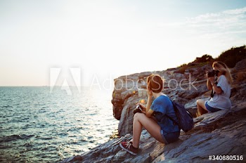 Women taking photo by seashore