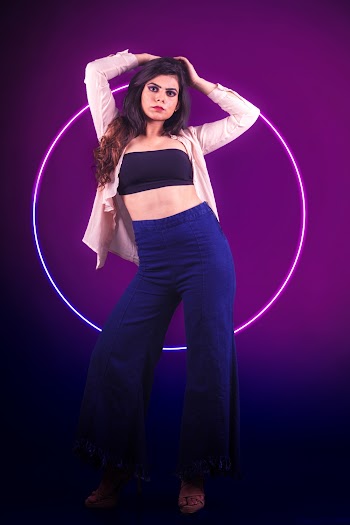 Women wearing a black crop top and blue pants