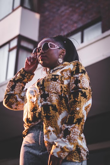 Women wearing a floral top standing near a building