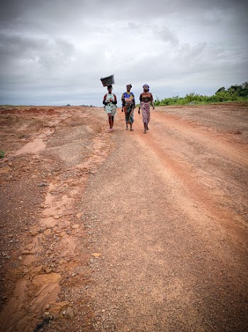 Women Wearing Multicolored Dress Walking on Sands Pathway