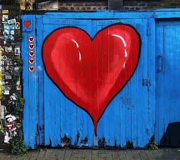 wooden gate with red and blue heart paint