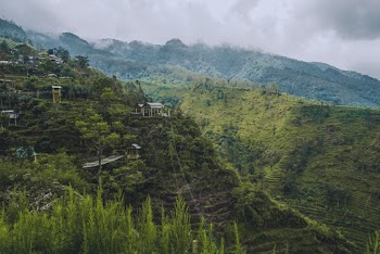 Wooden Houses on Cliff Under Gray Sky