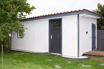 wooden white log cabin on home garden meadow
