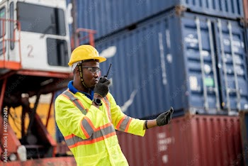 Worker man in protective safety jumpsuit uniform with yellow hardhat and use  Walkie Talkie check container at cargo shipping warehouse. transportation import,export logistic industrial service