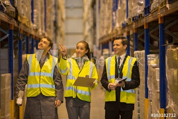 Workers talking and examining boxes in distribution warehouse