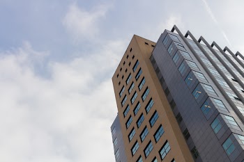 Worm's-eye View of High Rise Building Under White Sky