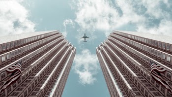 Worm's-eye view Photo of Plane Between Two High-rise Buildings