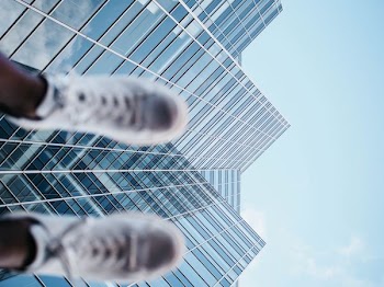worm's-eye photography of person raising his sneakers