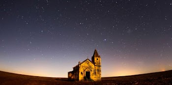 worm's eye view photography of cathedral under gray skies filled of stars