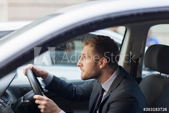 Worried businessman driving car in rain