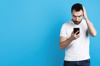 Worried man looking at smartphone Free Photo