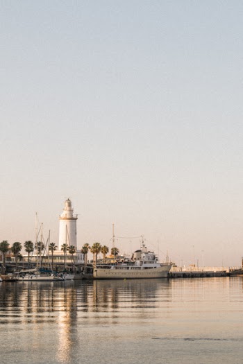 Yachts on Body of Water Near Lighthouse Tower