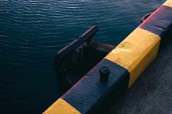 Yellow and Black Painted Bar Near Body of Water
