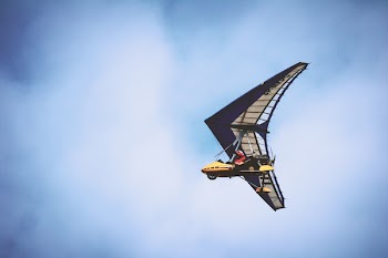 Yellow and Black Plane Under Blue Clouds