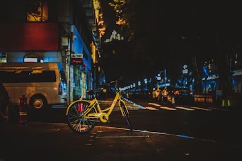 yellow bicycle park beside road during nighttime