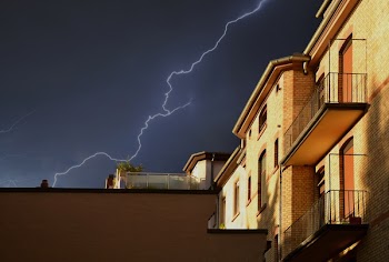 Yellow Building Under Thunderstorm in Black Sky