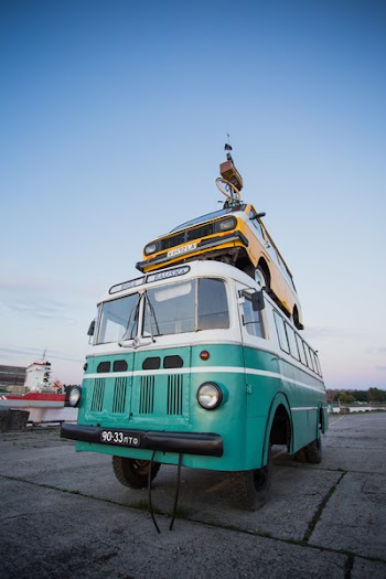 Yellow Car on Top of Teal and White Van