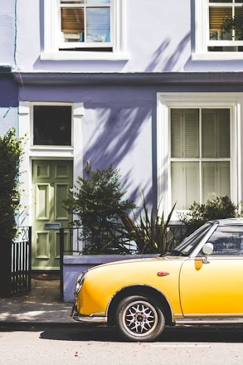 yellow car parked outside house