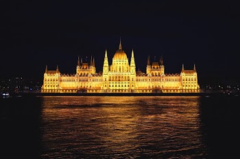 Yellow Castle Near Body of Water at Night Time