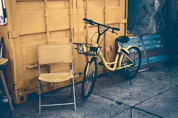 yellow city bike leaning on wall
