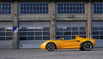 Yellow Coupe Parked Near Brown Painted Warehouse