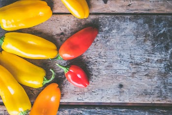Yellow, Orange, and Red Peppers on Wooden Surface