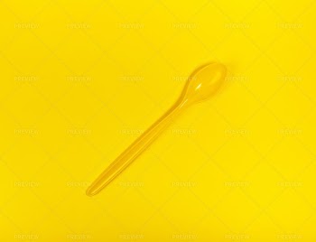 Yellow Spoon On A Yellow Background