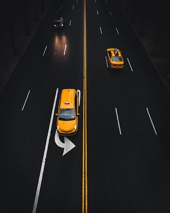 yellow SUV on road with left turn sign
