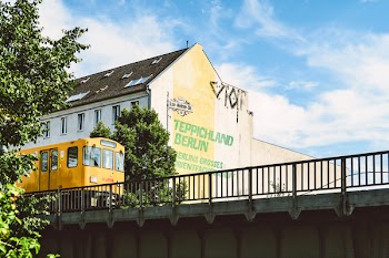 Yellow Train Beside Teppichland Berun Building