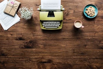 yellow typewriter near white petaled flowers