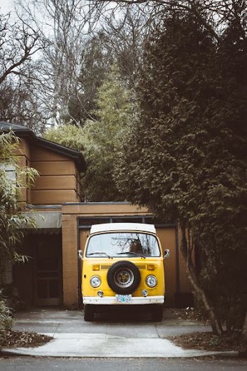 yellow vehicle park near wooden house