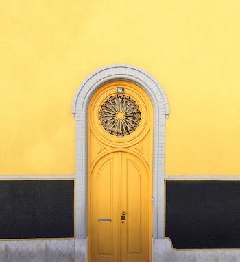 yellow wooden door between yellow wall