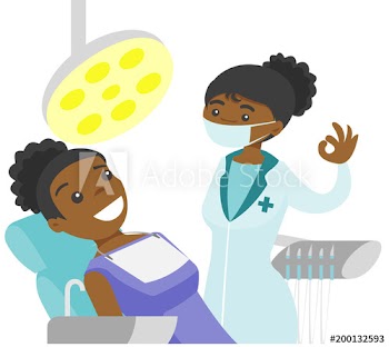 Young african-american dentist standing next to the dental chair with a patient and showing ok sign in the dental clinic