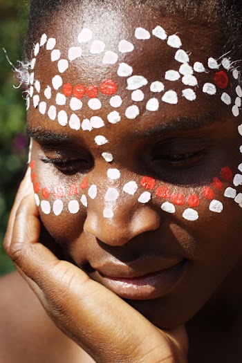 Young African girl, tribal painted face in white and red, this image is a straight RAW conversion, with powerfull highlights to emphase the black skin,